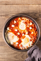 Shakshuka made of poached eggs in tomato pepper sauce
