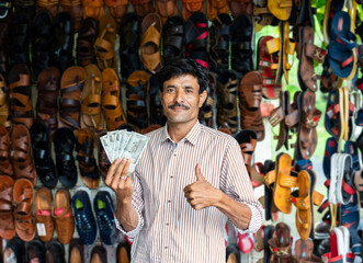 Indian man selling footwear or chappal at roadside shop