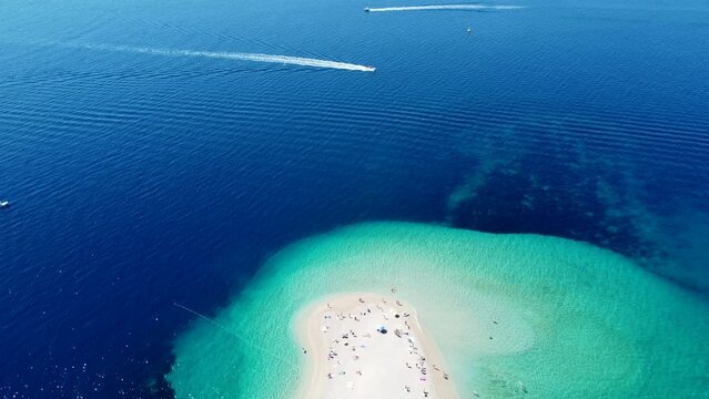 Drone view of Zlatni Rat (Golden Horn or Golden Cape), famous beach on Brac Island in Croatia, with people and boats. Tourists enjoying summer holidays. Croatian destination on Adriatic Sea