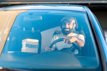 Smiling Arabic Deliveryman Driving Auto Loaded With Carton Boxes