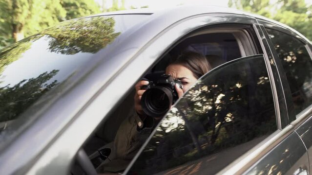 Woman private detective or paparazzi with camera spying from car