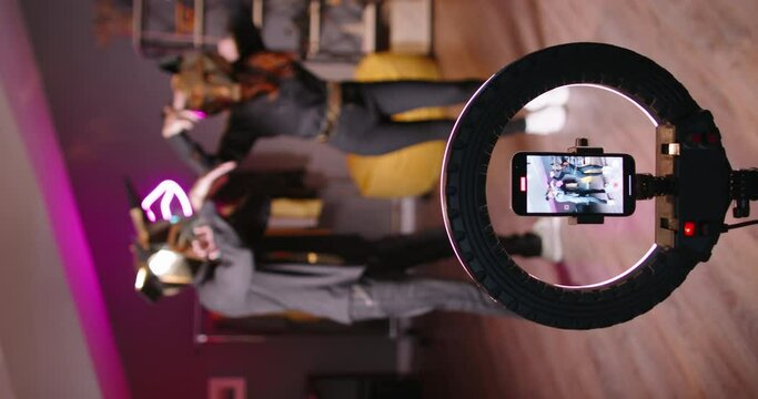 Two dancers record trending reels for social media channel. In halloween masks unknown unrecognizable. Bull and wolf masks vertical video. Tiktokers shoot video trend, concept of virtual life, reels 