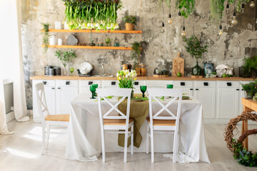 Interior design scandinavian kitchen with table and chair. Cozy Wooden white cuisine decorated with flowers and decor. Kitchen utensils, dishes, plates on shelves. Stylish dining room with furniture	