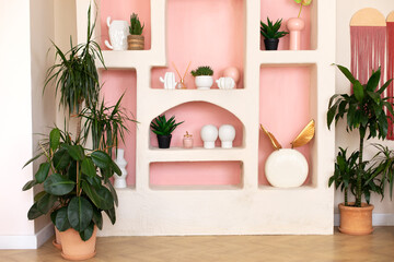 Stylish interior of wabi sabi style living room with design shelf with home decoration and plants...