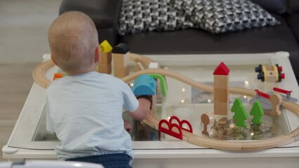 cute toddler child playing with toy wooden railroad at home - Powered by Adobe