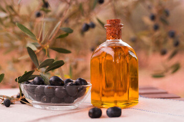 Olive oil in a glass bottle and green olives