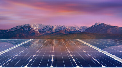 Solar panels with mountain landscape at sunset. Green energy concept.