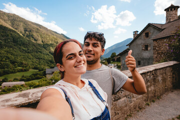 Selfie of a young couple doing rural tourism in a mountain village. Holiday trip and outdoor summer vacation in Huesca, Spain