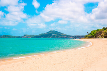 Sea tropical landscape. Blue sea with a wide sandy beach and a mountain on the horizon. Travel and tourism.
