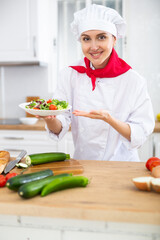 Portrait of positive woman chef presenting salad