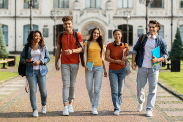 Group of cheerful college students walking out of campus together