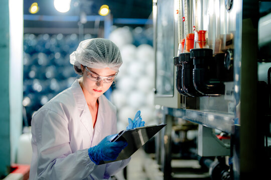 scientist worker checking the quality of Reverse osmosis machine system at the industrial factory. Female worker recording data at the control panel with measure pressure for recycle portable plant.