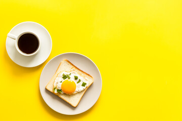 Fried eggs on toast bread and cup of black coffee, top view