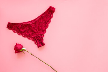 Elegant red lace lingerie bikini panties with red rose, top view