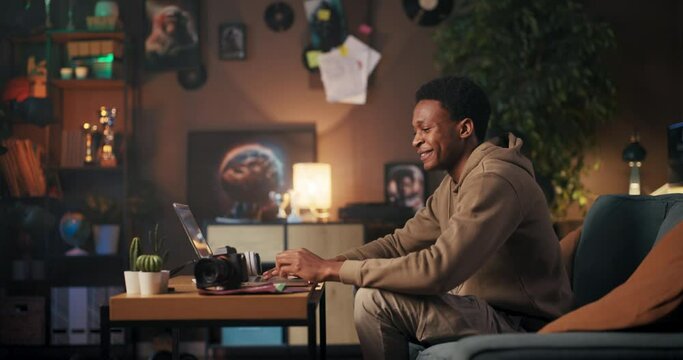 Music Producer: An African American man creating music on his computer while wearing headphones, smiling, and dancing to the beats he produces.