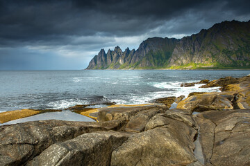 Dramatic rocky shoreline with turbulent waves and stormy sky