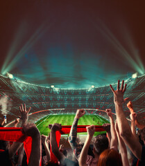 Football scene at night match with with cheering fans at the stadium