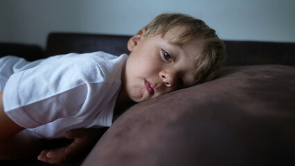 Child on couch resting preparing to sleep restful little kid on sofa nap