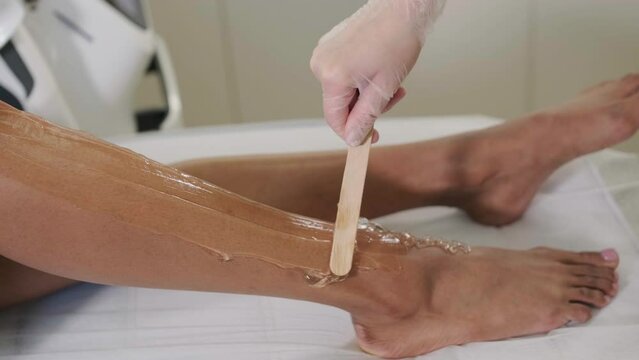 Laser epilation and cosmetology in beauty salon. Cosmetology, spa and hair removal concept. Laser hair removal procedure of female legs. doctor in gloves.