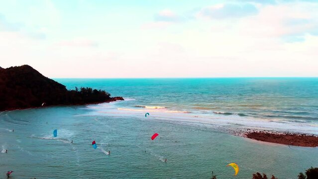Athletes rides on wild ocean waves of a living reef in Pacific Ocean. One of the best surf spots on the planet. Kiteboarding is sports hobby that inspires you and makes you feel spirit of freedom.