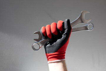 Working tools for repair. Man in denim holding grey wrenches in his hands. Front view