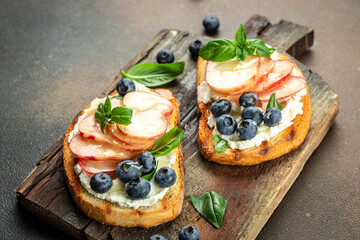 bread toast with cream cheese, honey, peaches and blueberries, Fresh healthy appetizer snack, place for text, top view
