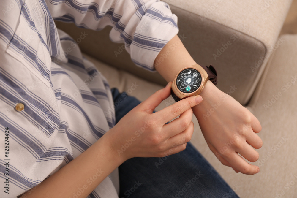 Poster woman setting smart home control system via smartwatch indoors, closeup. app interface with icons on