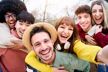 Selfie of a group of multiracial students and laughing a lot while they they look at camera. They...