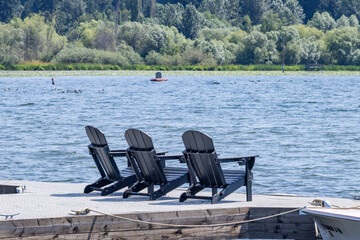 Three Adirondack chairs on pier