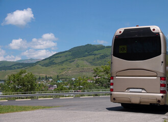 Tourist beige modern bus traveling on a mountain road. The concept of tourist and bus tourism.