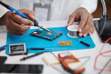 Closeup image of technician soldering computer hard drive