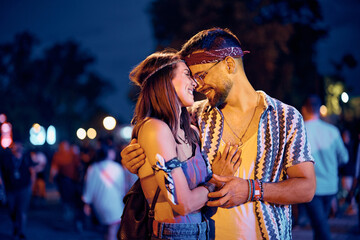 Happy couple in love at open air music concert at night.