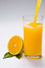 Copo de suco de laranja, fruta e folha