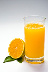 Copo de suco de laranja, fruta e folha