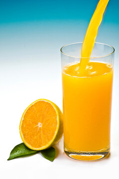 Copo de suco de laranja, fruta e folha