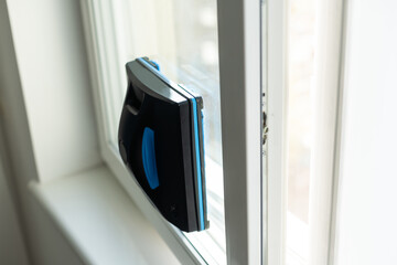 Modern window washer robot performs work on a dirty window. Cleaning the house with smart devices....