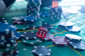 Red dice, game cards and colored chips for playing poker on gaming table in casino. Concept of...