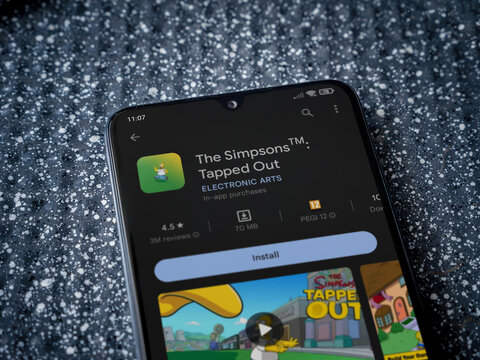 The Simpsons Tapped Out app play store page on smartphone on a metallic background