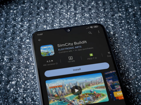 SimCity BuildIt app play store page on smartphone on a metallic background