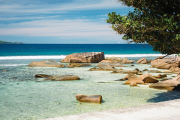 Big granite rocks on the Grand Anse beach. La Digue island, Seychelles. Tropical landscape with sunny sky.