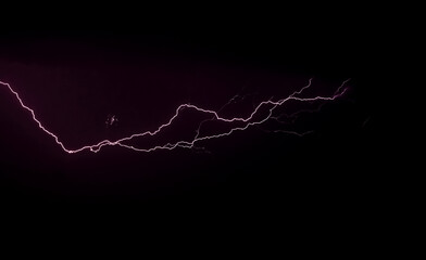 Flash of lightning bolt in stormy night sky