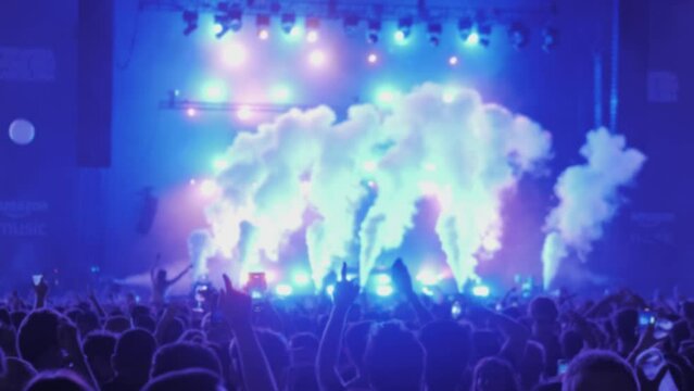 Concert people crowd applause and dancing jumping with phone camera, making video, festival music show stage. Crowd singing artist cheering, rock events. 