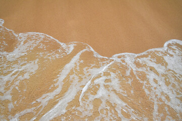 Sea surf wave over beach sand