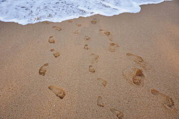 Fototapeta na wymiar Child footprints on sand sea shore