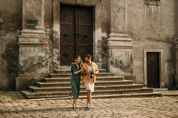 A loving couple strolls along a vibrant street, admiring the colorful buildings and street art.