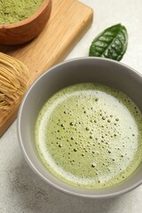 Cup of fresh green matcha tea on light grey table
