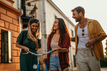 Tourists from around the world, dressed in colorful attire, explore the city's vibrant neighborhoods by bicycle, immersing themselves in its diversity.