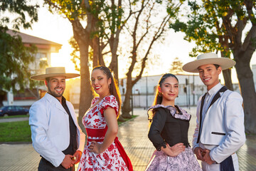 portrait of a cueca chilean folk dance group of two couples dressed as huaso in the city square of...