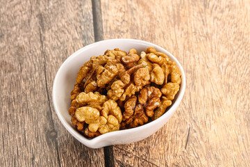 Cracked unshelled walnut in the bowl