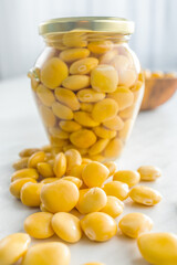 Lupini beans in brine. Pickled lupin in jar on kitchen table.